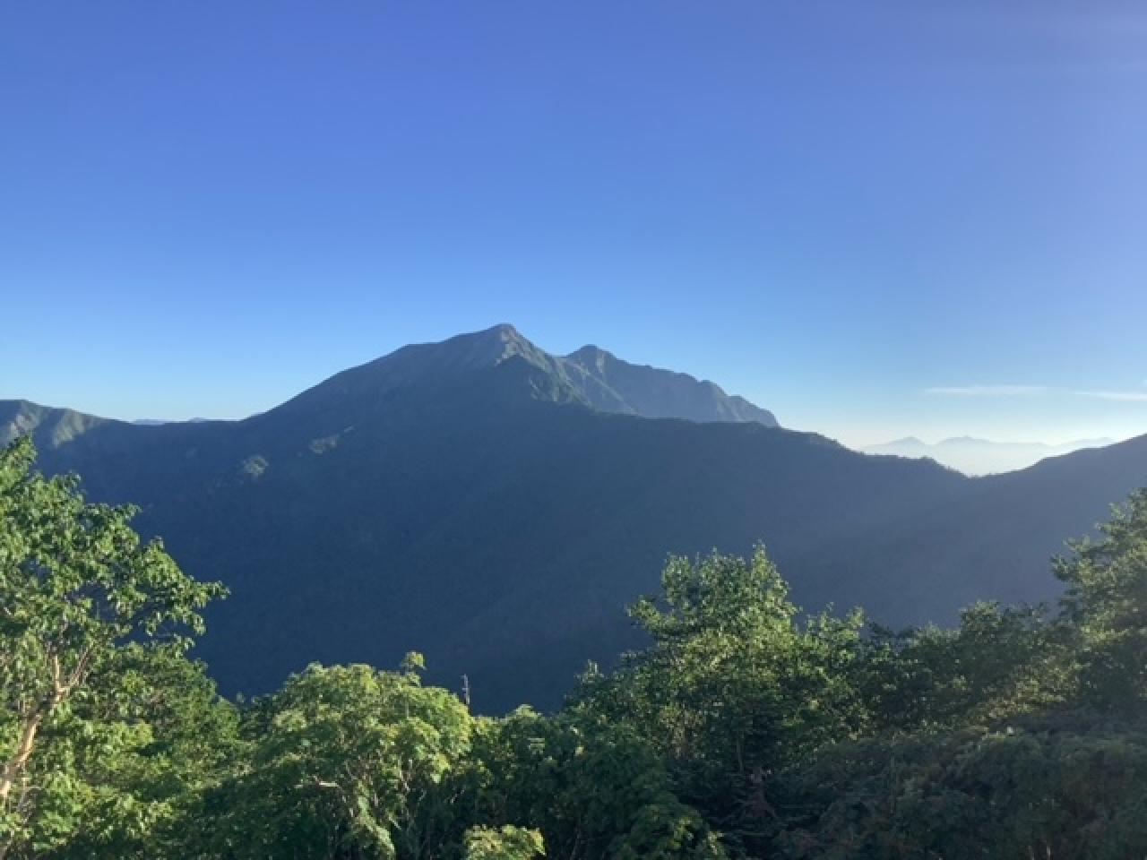 朝は雲ひとつない夏空の下、鹿島槍ヶ岳屹立　種池山荘より