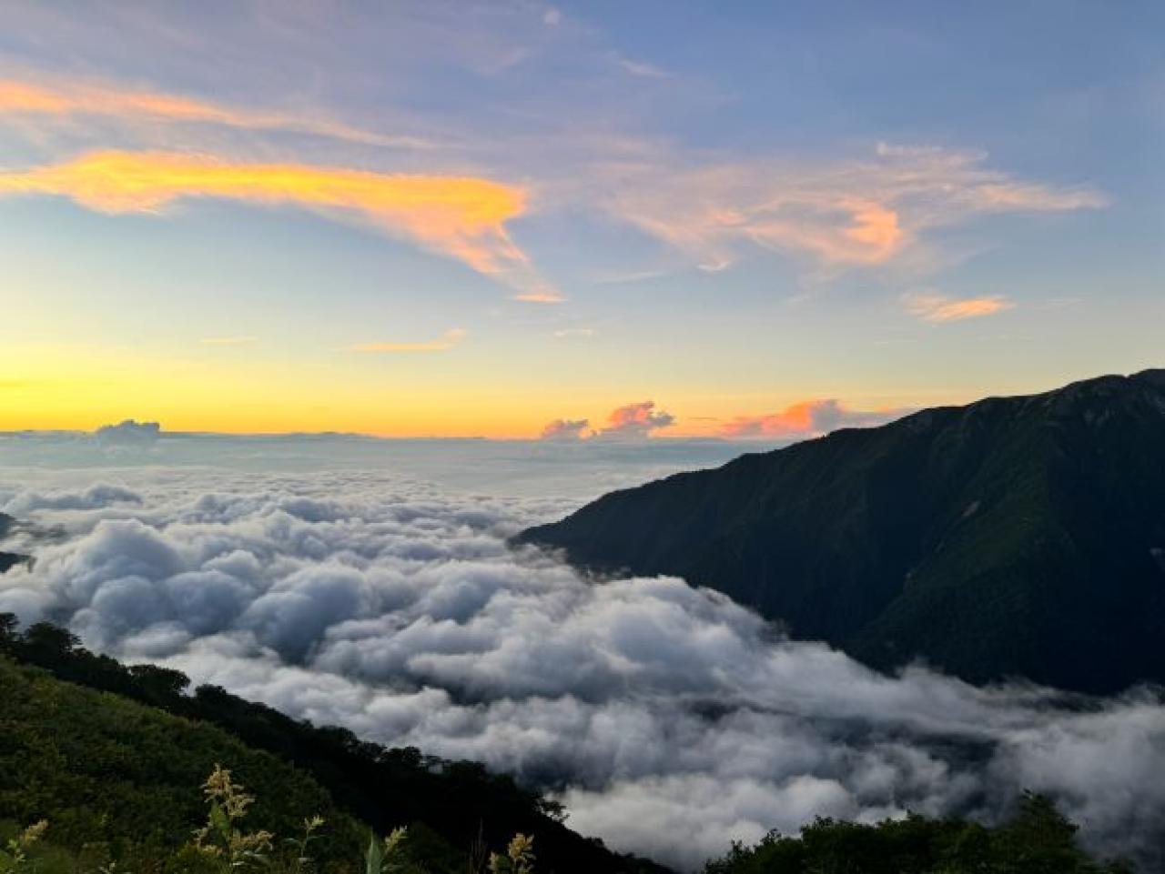 雲海の下は大町。薄っすら赤く染まる東の空、遠く奥秩父の山や富士山辺りには早朝から積乱雲が沸き立ちます。(新越山荘)