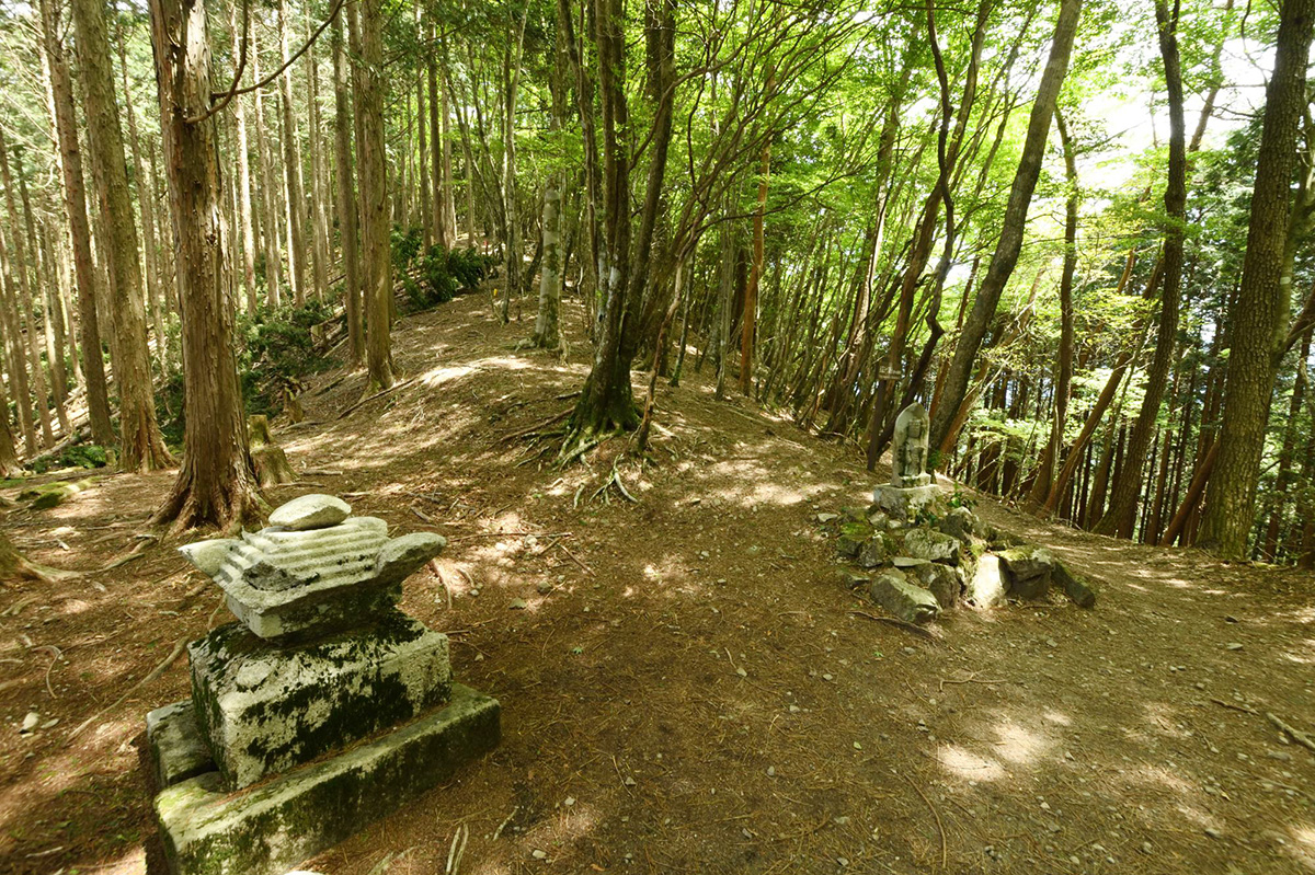 〉果無峠。左は宝篋印塔の一部